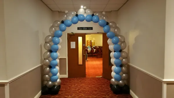 Blue and silver balloon arch framing a doorway
