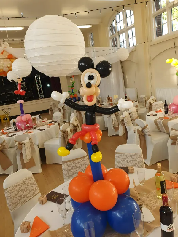 Large Mickey Mouse balloon sculpture on a colorful column
